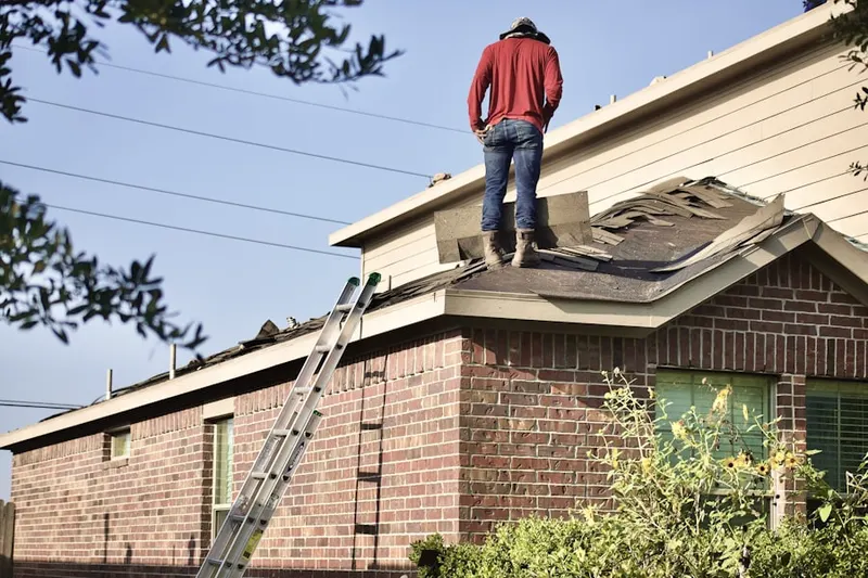 Professional roofer working on a residential roof in East Westwood